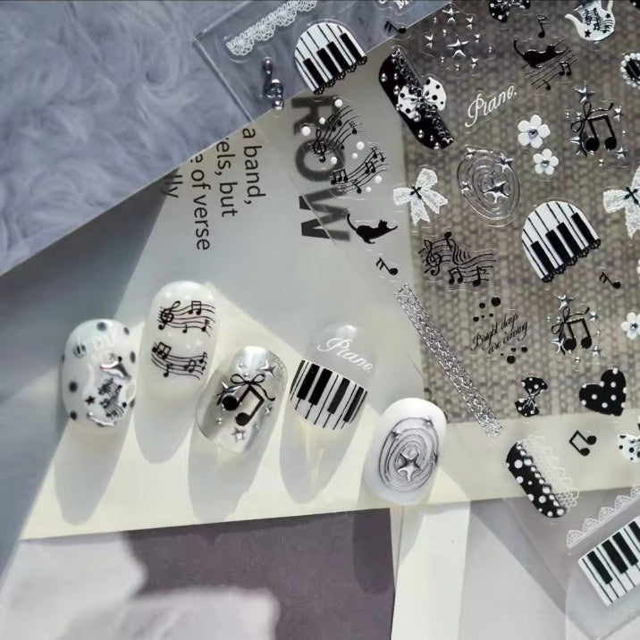 Music note and piano nail decals shown on sample nails