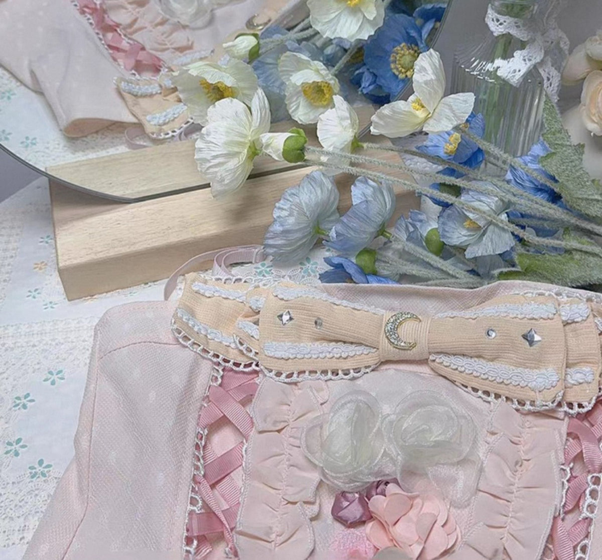 Close up of pink ruffled corset top with bows and floral details